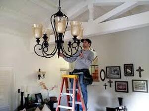 Electrician installing a chandelier